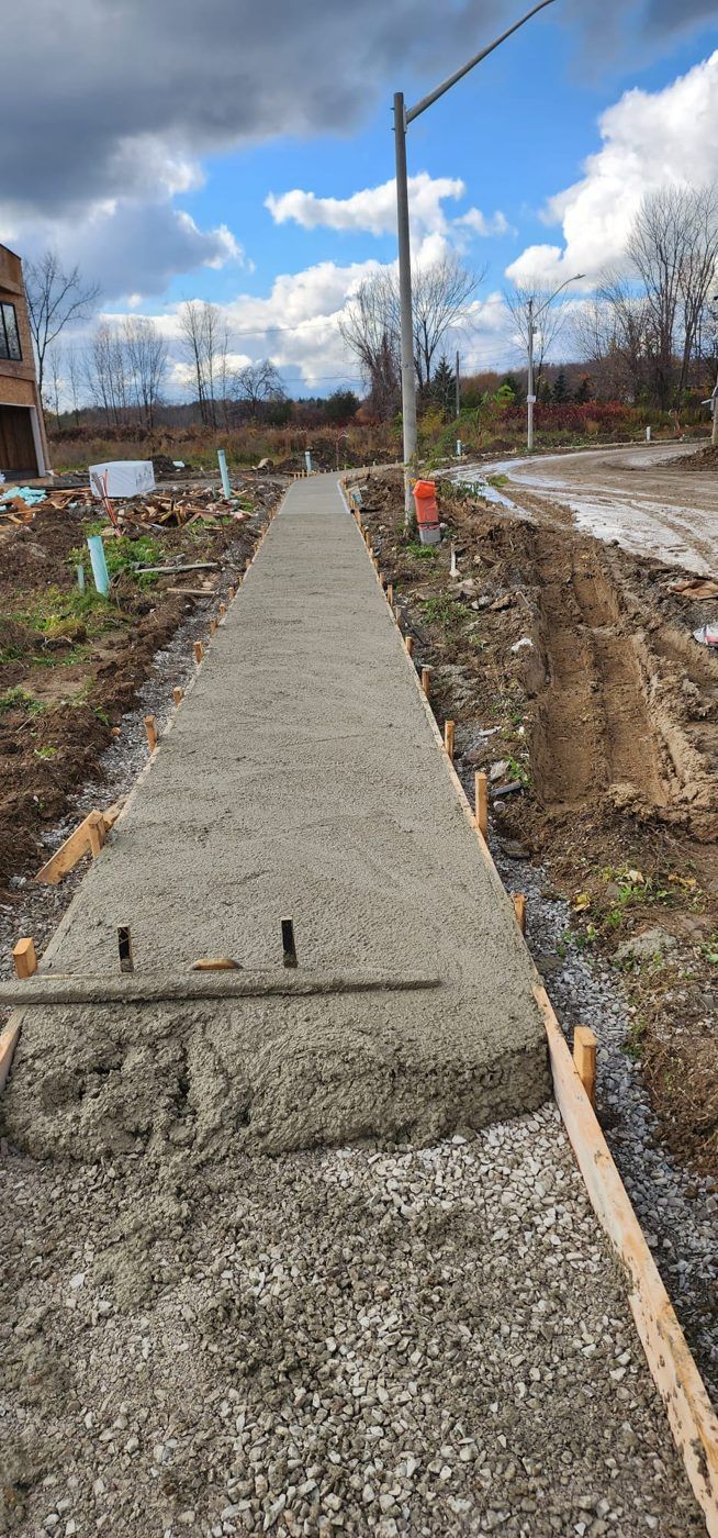 Freshly poured concrete sidewalk in wood forms