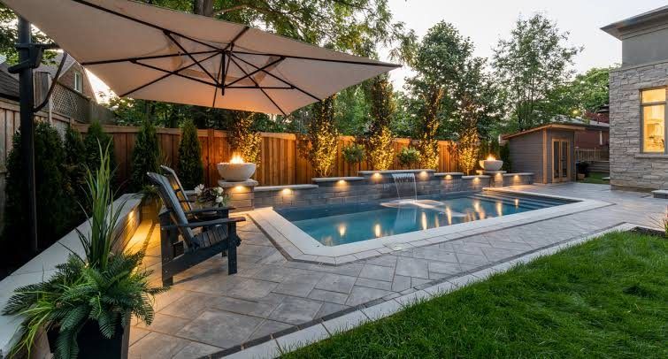 Interlock pool patio with stone retaining wall and lighting