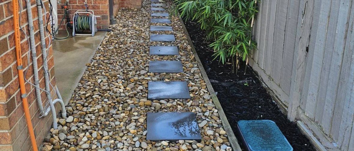 Side pathway with stepping stones and river rock